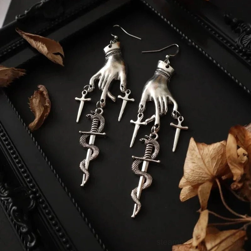 Gothic severed hand dangle earrings with serpent sword charms and collar detail angled view