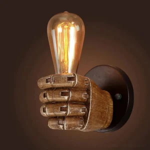 Industrial fist lamp with mechanically jointed resin fist, tall Edison filament bulb, and dark metal base against dark studio background