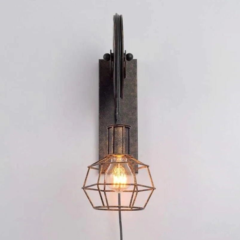 Minimalist steampunk wall sconce with brushed dark metal construction, flat-top pulley bracket, and compact geometric wire cage lampshade, photographed directly from front