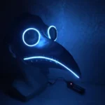 LED plague doctor steampunk mask with cyan LED strips illuminated on eyes and beak, displayed on mannequin head in dark environment with portable power controller