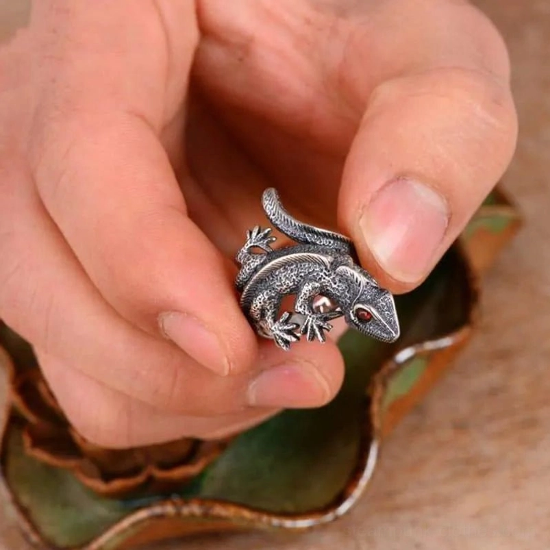 Detail view of silver lizard ring showing reptile scale texture, red gemstone eye focal point, vintage patina, and mechanical steampunk artistry