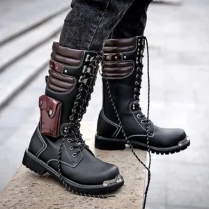 Men's black steampunk combat boots with wine red accents and metal toe cap, worn by male model on concrete sidewalk