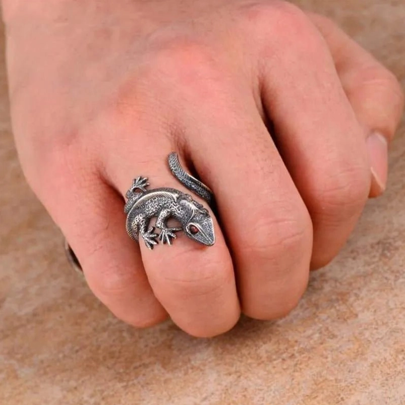 Mens steampunk lizard ring worn on hand, front-facing close-up showing worn silver tone, scale details, and gothic aesthetic on wooden surface