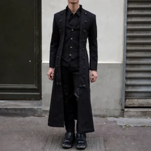 Men's steampunk long coat front view with brass buttons and layered vest overlay, worn by male model on urban street