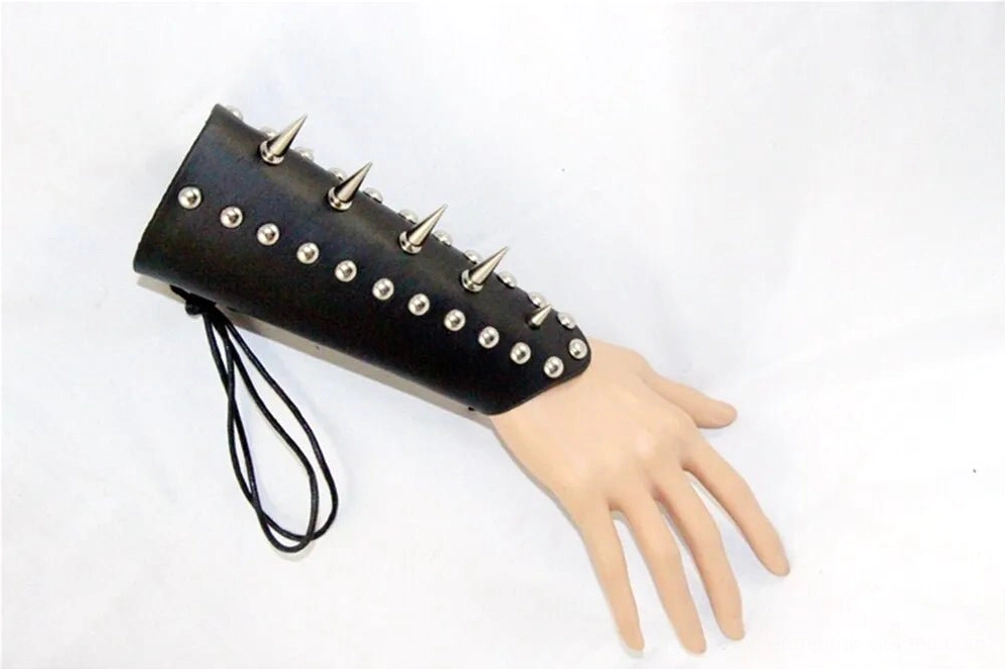 Mini spike leather wrist armor with small conical spikes and round studs, worn on mannequin hand showing side view and compact profile