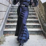 Navy blue mermaid steampunk fishtail skirt with cascading ruffles and side lace-up detail, worn on female model in outdoor stone setting