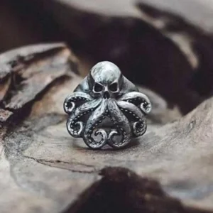 Octopus skull steampunk ring in silver-antique finish with carved tentacles, displayed on weathered wood surface in close-up detail