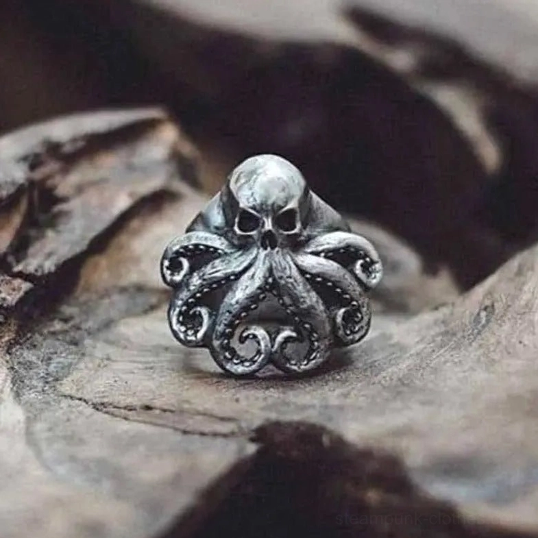 Octopus skull steampunk ring in silver-antique finish with carved tentacles, displayed on weathered wood surface in close-up detail