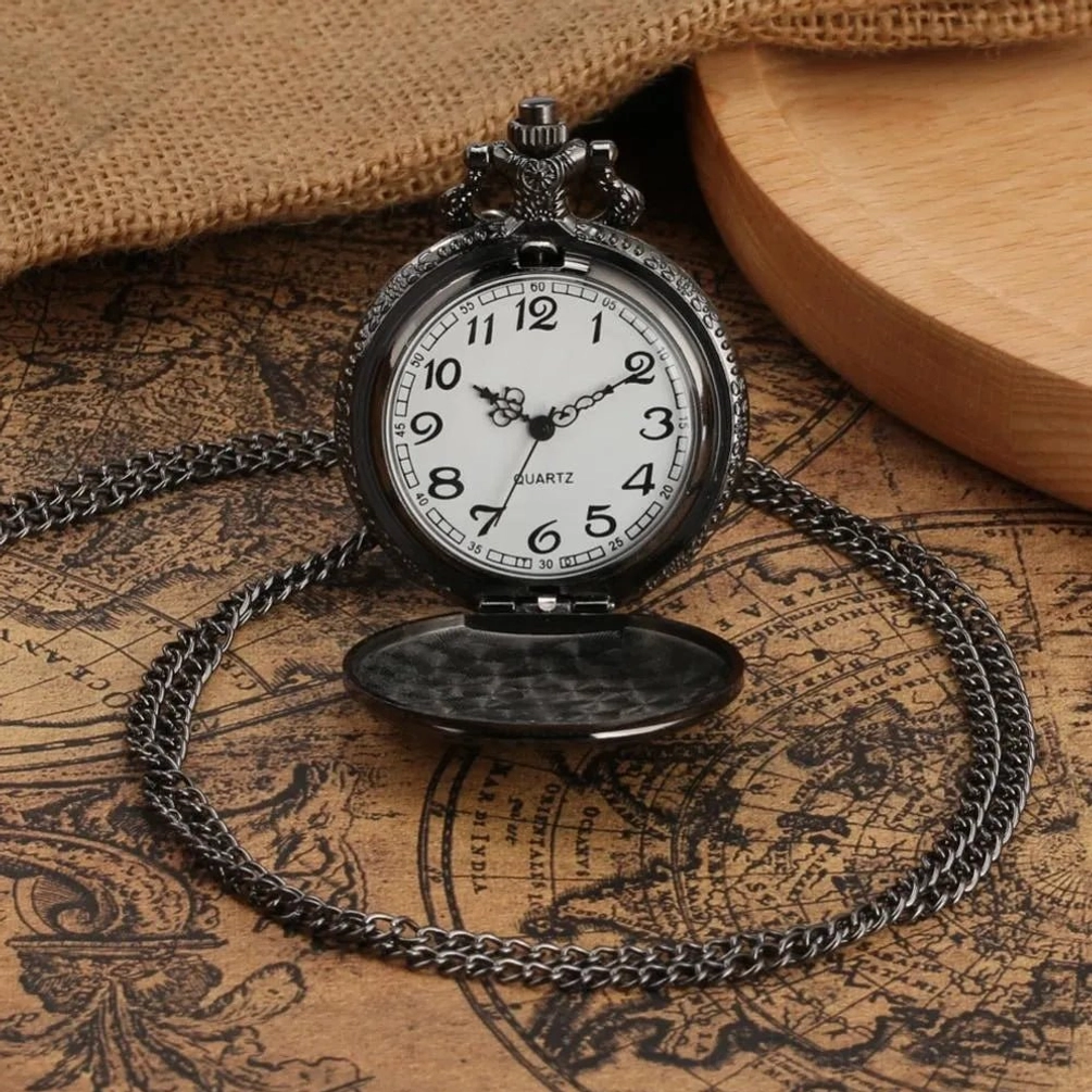 Open quartz pocket watch showing white dial with black numerals and twisted metal chain, gun-black stainless steel case on vintage map and wooden board