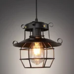 Oxford steampunk industrial pendant lamp with matte black wrought iron frame and intricate scroll accents on wire cage shade, front close-up studio view