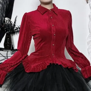 Red ribbed velvet steampunk blouse full upper body display with bronze front buttons and ruffled hem, studio gothic backdrop