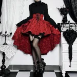 Red steampunk high-low skirt with layered ruffles and corset-style waistband on model, front low-angle view showcasing jacquard fabric texture and dramatic hem