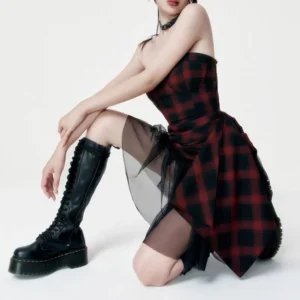 Red and black tartan steampunk dress side profile showing sheer black tulle panel detail, paired with lace-up combat boots - alternative fashion styling