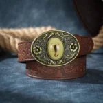 Scorpio steampunk belt featuring hand-carved bronze floral scorpion buckle with intricate inlay on embossed dark brown vegan leather, front flat lay view showcasing ornate buckle detail and premium craftsmanship