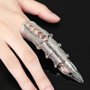Silver articulated steampunk finger armor ring with segmented joints and hollow cutout designs, worn on female hand against black studio background
