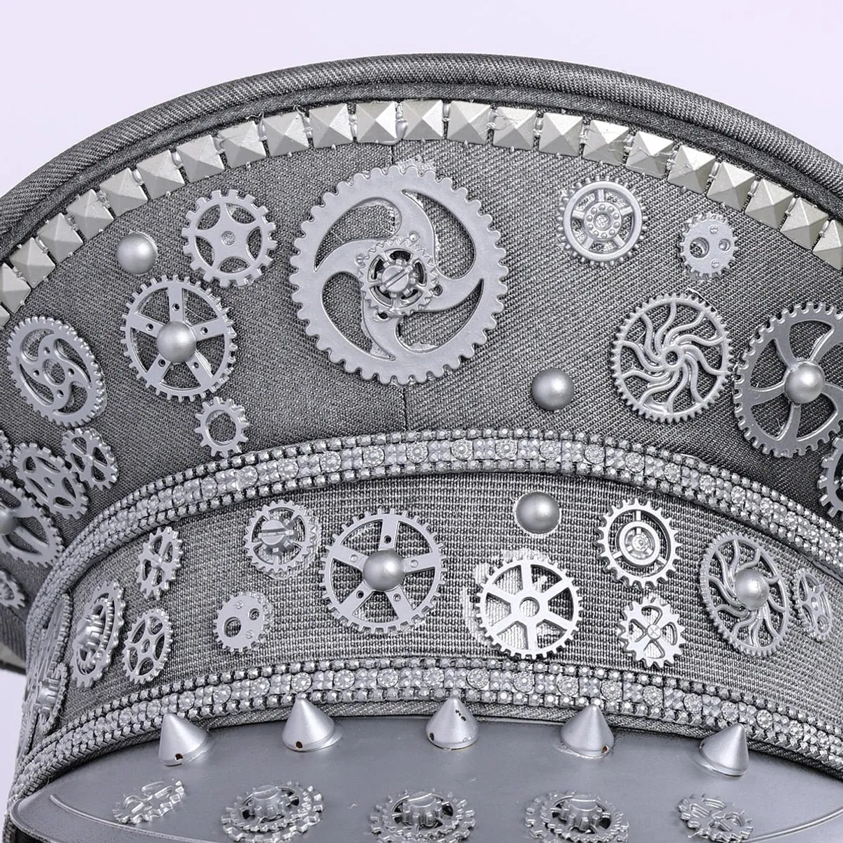 Close-up detail of silver steampunk aviator cap mechanical gears, spikes and woven fabric