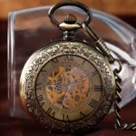Skeleton steampunk pocket watch front three-quarter view with exposed mechanical gears, carved floral patterns, and Roman numerals on dark fabric