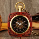 Red wooden square steampunk pocket watch with brass trim and skeleton Roman numeral dial, front overhead view showing carved scroll details