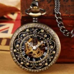 Star steampunk pocket watch with bronze hollow floral case and black dial, showcasing exposed golden mechanical movement in vintage wooden box setting with retro newspaper backdrop
