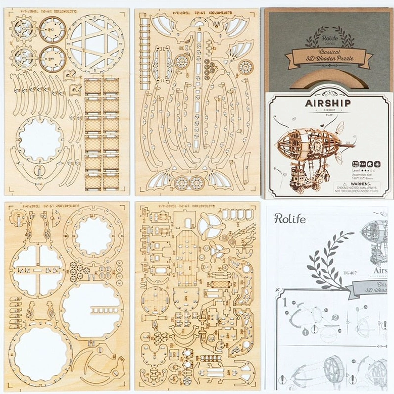 Steampunk airship puzzle kit flat lay - laser-cut wooden components, instruction manual, and original product box packaging