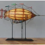 Yellow-striped steampunk airship model with black metal framework, signal flags, and attached ladder - left side view on wooden display table