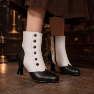 Victorian steampunk ankle boots with two-tone black and white vegan leather, decorative front buttons, side zipper, and 2.7-inch kitten heel - front close-up view showcasing dual-closure lace-up design