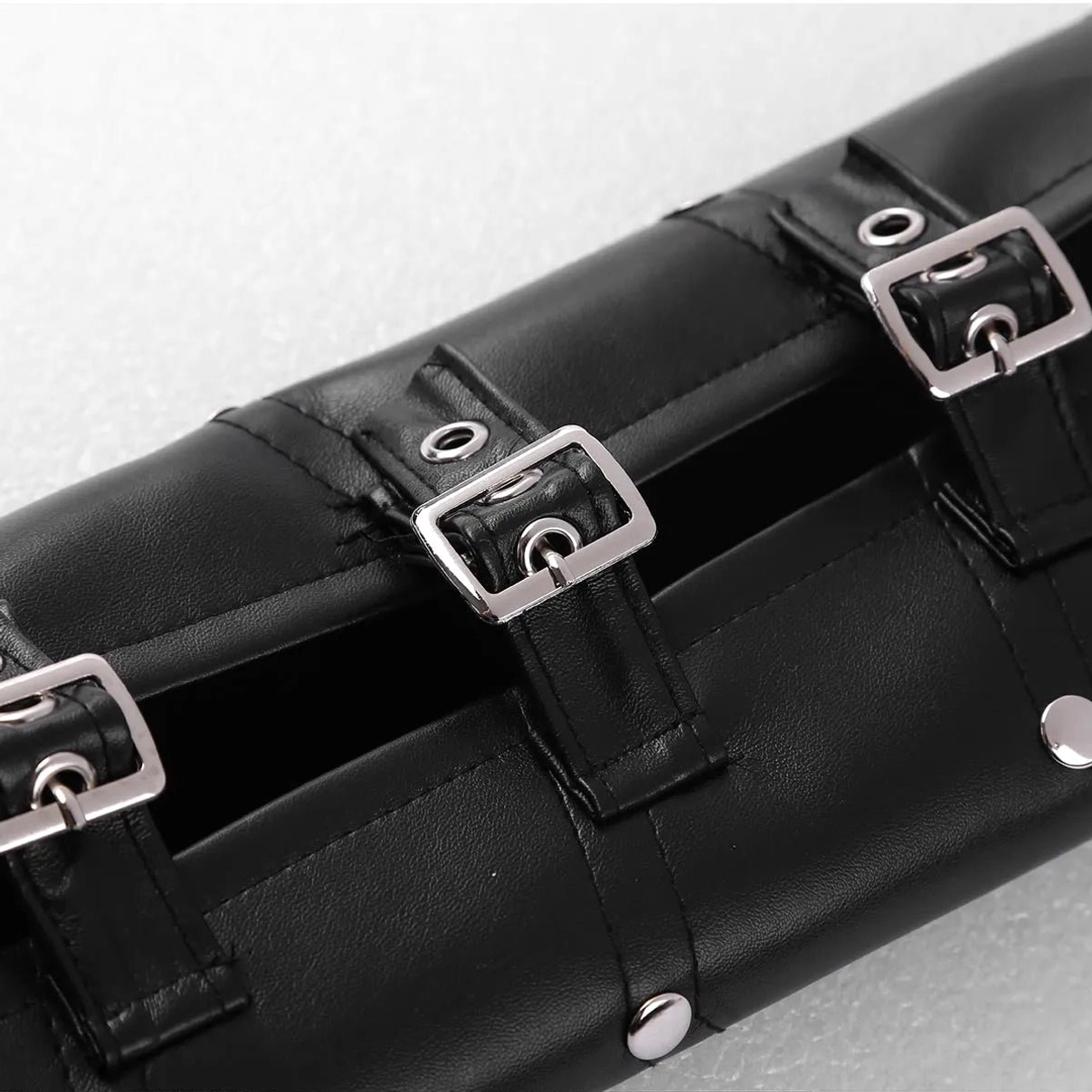 Close-up detail of steampunk armor buckle system showing multiple silver square buckles, reinforced metal eyelets, and adjustable black leather straps for customizable fit