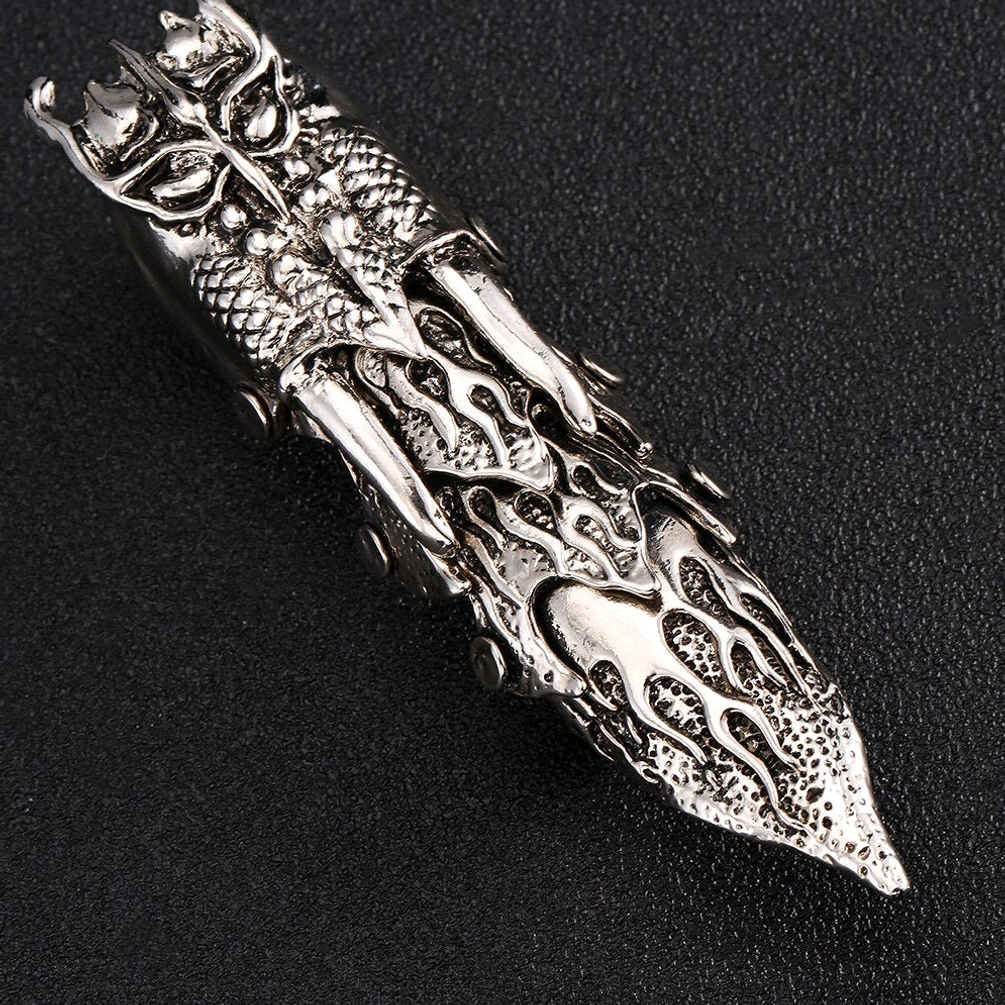 Top-down flat lay perspective of articulated steampunk owl finger armor showing the dual-loop construction, hand-carved owl head apex, segmented articulated joints, full flame engraving patterns, and universal unisex design