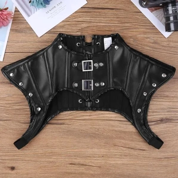 Steampunk armor vest flat lay top view showing dual front buckles, structured shoulder armor pads, and strategic cutout pattern on black faux leather