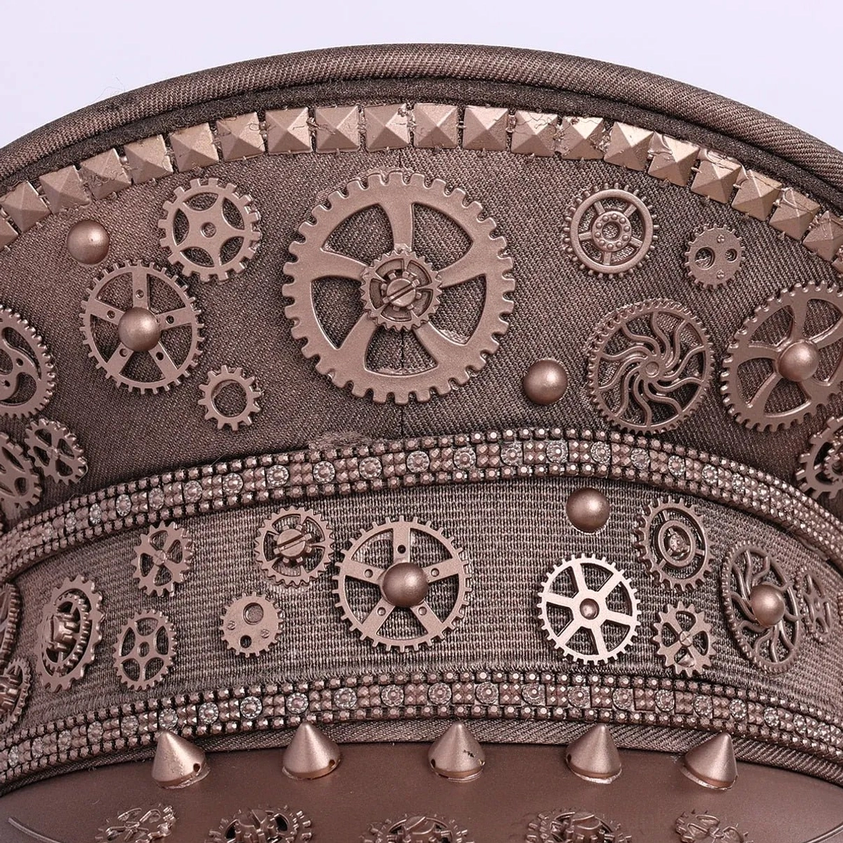 Close-up detail of steampunk aviator cap bronze gears, pyramid studs and spike edging