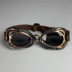 Steampunk aviator goggles with bronze metal frame and dark tinted lenses, front flat view showing vintage design