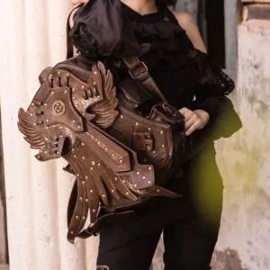 Steampunk leather rucksack with riveted decorative armor plating held by female model in black ruffled blouse against weathered vintage wall, highlighting front central emblem