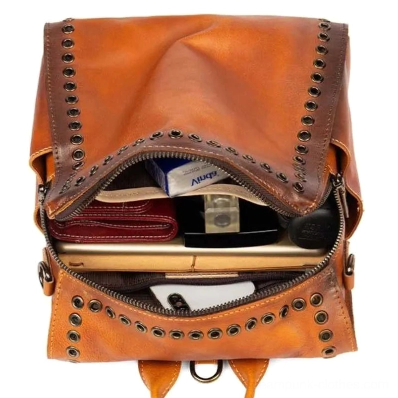 Open vintage steampunk leather backpack top-down view revealing spacious interior compartment with organized storage slots, cotton interior lining, and personal item capacity for digital and analog essentials