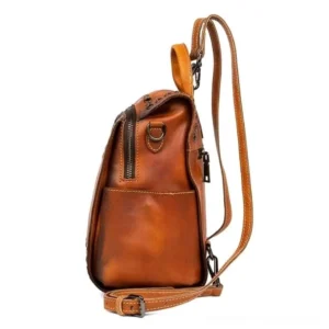 Steampunk leather backpack rear view displaying adjustable shoulder straps with metal hardware, exterior side pocket for quick access, and top carry handle for alternative carrying methods