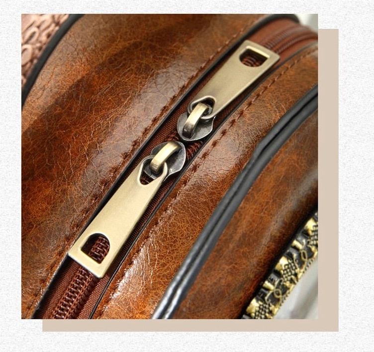 Close-up detail of steampunk bag hardware including textured genuine leather surface, metal zipper pulls, brass trim accents, and mechanical craftsmanship