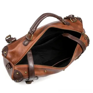 Steampunk leather messenger bag oblique angle showing brown vintage leather construction, metal hardware, removable shoulder strap, and black interior lining details