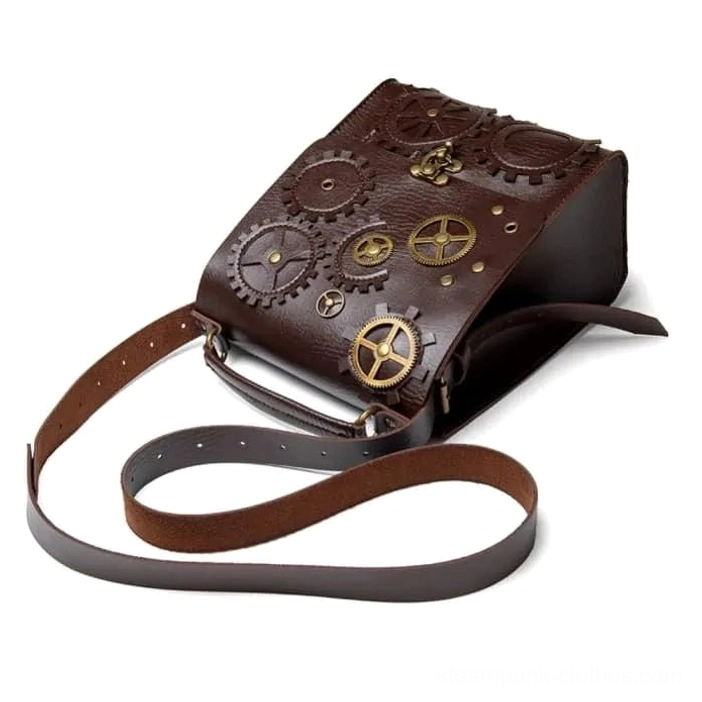 Steampunk crossbody bag side profile displaying pebbled brown leather, two-tone detachable shoulder strap, vintage brass gear ornaments, and top handle carrying option