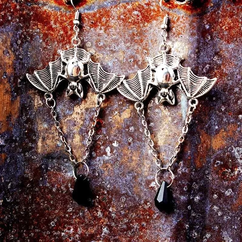 Pair of antique silver bat steampunk drop earrings with faceted black teardrop beads and connected chain links on weathered metal background