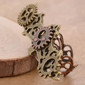 Adjustable steampunk bat ring side angle view on wooden slice, displaying multi-layer bronze copper gear decorations and dimensional craftsmanship of the winged design