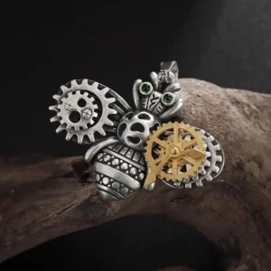 Steampunk bee pendant showcasing intricate dual-tone brass and silver construction with mechanical gear embellishments and luminous green rhinestone eyes - front right angle detail shot