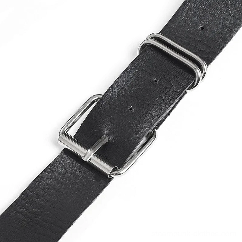 Close-up flat lay of steampunk belt buckle hardware featuring silver rectangular pin buckle and dual O-ring adjustment mechanisms on black vegan leather strap