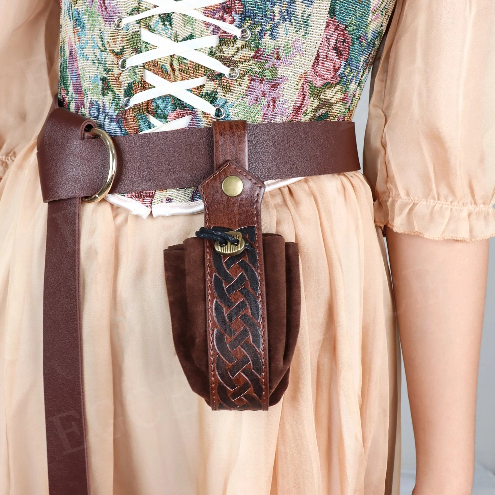 Close-up detail of steampunk brown leather belt pouch featuring intricate Celtic knot woven textile pattern and metal snap button hardware, showcasing craftsmanship and industrial aesthetic