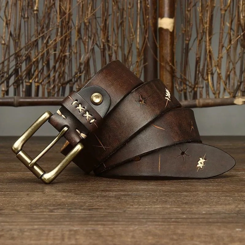Steampunk corset belt detail showcasing intricate hand-stitched cross-stitch work, engraved geometric patterns, antique brass hardware with warm patina, overhead angle on natural wooden backdrop—demonstrating precision Victorian-era inspired craftsmanship