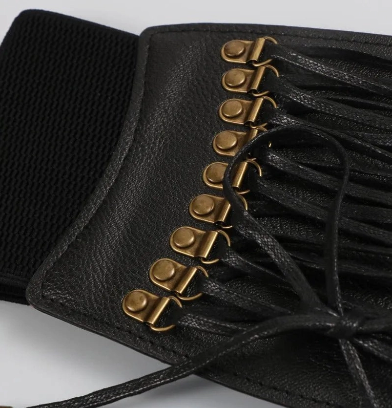 Side angle close-up of steampunk belt lace-up area showcasing antique bronze grommets, tied black leather laces, and reinforced stitching detail, emphasizing mechanical craftsmanship and vintage authenticity