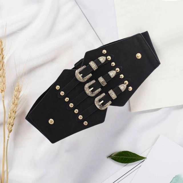 Steampunk corset waist belt product photography showing black leather with silver engraved triple buckles and gold studs on decorative background