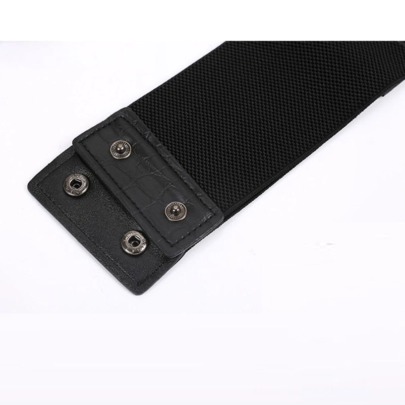 Steampunk waist belt closure mechanism featuring black elastic fabric backing, faux leather straps, and metal snap button attachment showing functional design and secure fastening system