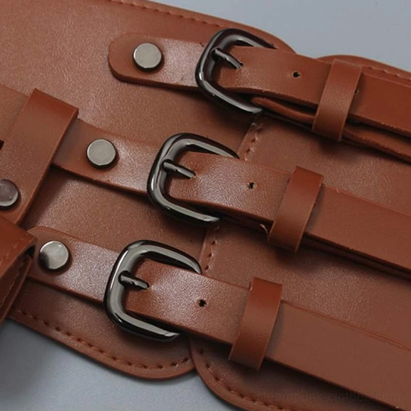 Detailed view of steampunk corset belt's triple-strap construction showing three black matte metal buckles, adjustable hardware, and rivet decoration on brown faux leather material