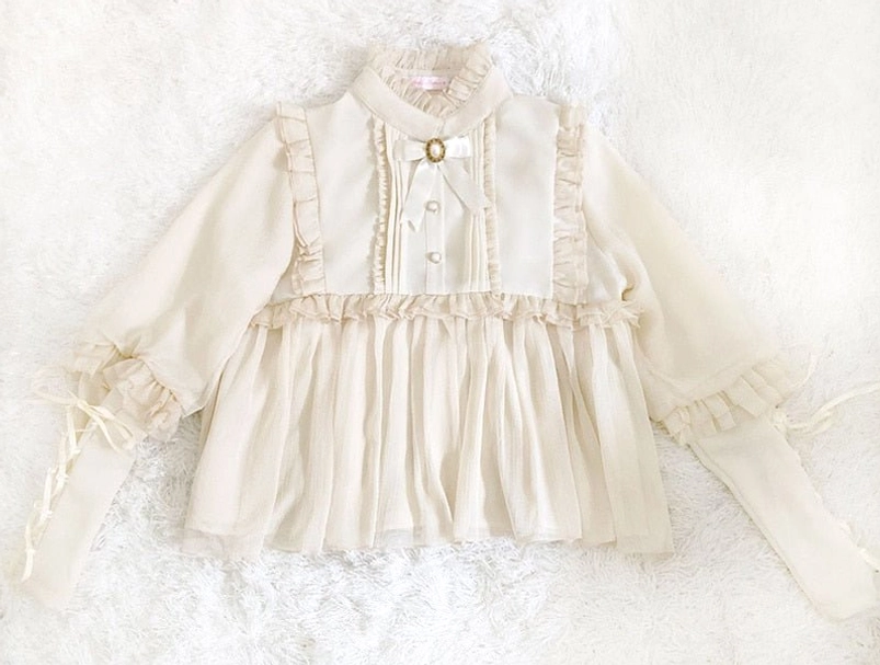 Cream white lolita steampunk blouse flat lay front view displaying buttoned stand collar, pleated hem and lace-up cuff details