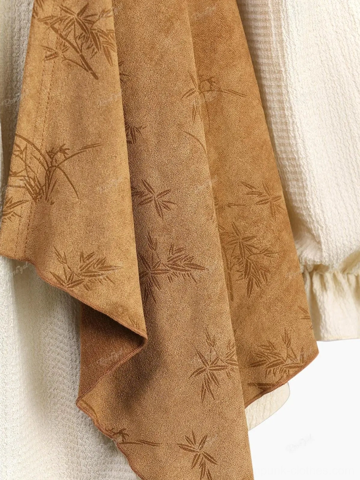 Side detail of steampunk blouse showing asymmetric suede panel and crinkled off-white fabric texture