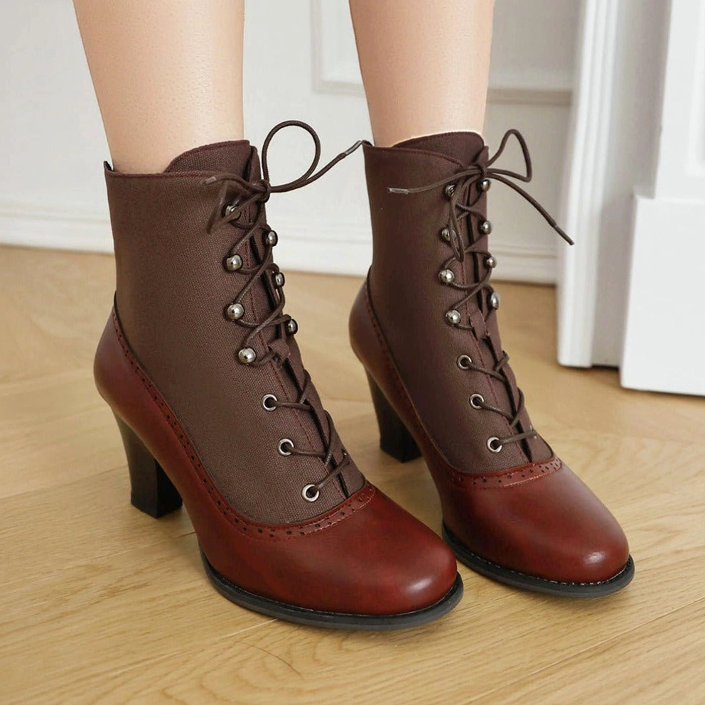 Steampunk Victorian lace-up boot flat lay - dark brown leather upper with reddish-brown toe cap, metal eyelets, industrial aesthetic